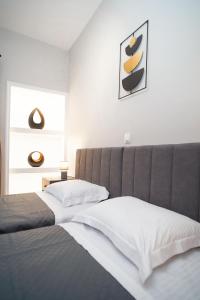 una camera con letto e testiera grigia di Elarion Elegant Port Apartment a Città di Corfù