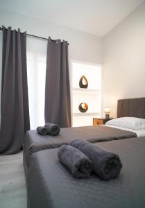 una camera da letto con due letti con asciugamani sopra di Elarion Elegant Port Apartment a Città di Corfù