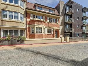 an empty street in front of a brick building at Maison 't Blyhuis in De Panne in De Panne
