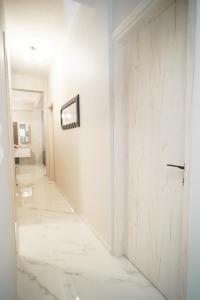 un corridoio con una parete bianca e una porta di Elarion Elegant Port Apartment a Città di Corfù