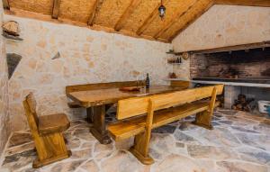 a wooden table and bench in a room with a fireplace at Gorgeous Home In Popovici With Wifi in Popović