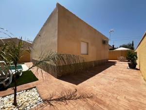 - un bâtiment avec un mur en pierre à côté d'une terrasse dans l'établissement Villas Privadas EL DESCANSO, à La Rinconada