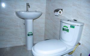 un baño con inodoro y lavabo en Lexus Homes, en Nakuru