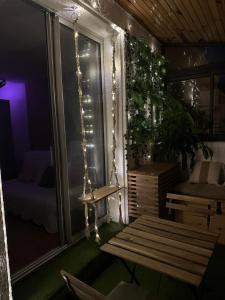 a porch with a swing and a window with lights at SERENATA - Studio climatisé sur le Port - Piscine & Tennis in Sausset-les-Pins