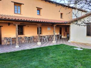 a patio with tables and chairs in front of a building at Don Camino Casa Aurea in Villalcázar de Sirga