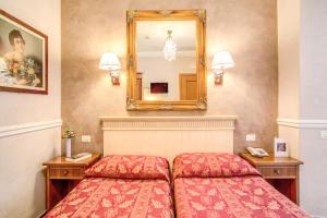 a hotel room with two beds and two lamps at Hotel Caravaggio in Rome
