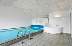 a large swimming pool with a tub in a bathroom at Amazing Home In Blåvand With Sauna in Blåvand +23 photos