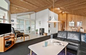 a living room with a couch and a table at Amazing Home In Blåvand With Sauna in Blåvand