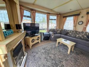 a living room with a couch and a tv at Superb Caravan With Decking Close To Hunstanton Beach In Norfolk Ref 23060S in Hunstanton