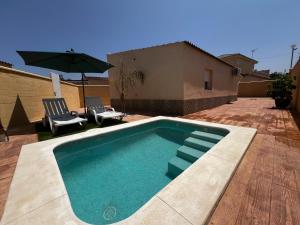 a swimming pool with two chairs and an umbrella at Villas Privadas EL DESCANSO in La Rinconada +128 photos