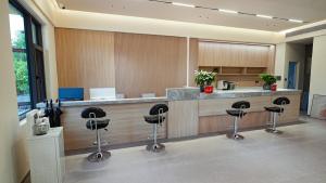 a lobby with a bar with stools at a counter at Zhangjiajie The Brookside Hotel& Tianmen National Forest Park & Free pick up service in Zhangjiajie