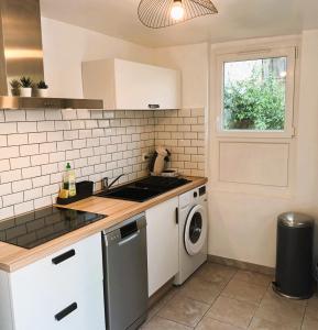 une cuisine avec un évier et une machine à laver dans l'établissement La Cachette - Maisonnette - Wifi - TV, à Tours