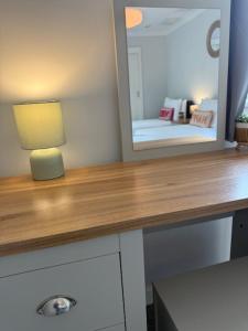 a desk with a mirror and a lamp on it at Lomond Villa in Fort William