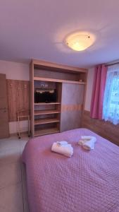 a bedroom with a large bed with two towels on it at Night and day 3 in Predazzo