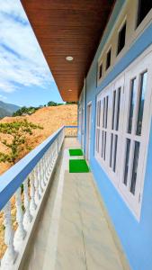 a blue building with a balcony with green grass at Tara devi homestay in Dirang Dzong