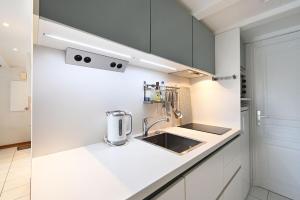 eine weiße Küche mit einer Spüle und einer Theke in der Unterkunft Vauban 125 Courtyard and parking in Saint-Martin-de-Ré + 7 Fotos