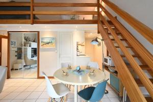 ein Wohnzimmer mit einem weißen Tisch und Stühlen in der Unterkunft Vauban 125 Courtyard and parking in Saint-Martin-de-Ré