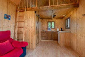 un divano rosso in una stanza di legno con cucina di Cortijo señora de las Angustias 1 ad Alanís Altre 26 foto