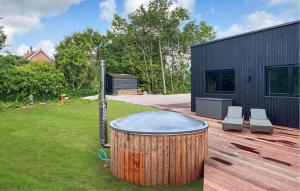 a hot tub on a deck next to a house at 5 Bedroom Lovely Home In Lemvig in Lemvig