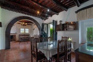 una cucina e una sala da pranzo con tavolo e sedie di Cortijo señora de las Angustias 1 ad Alanís