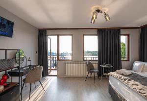 a bedroom with a bed and a desk and a balcony at Guest House Fotini 2 in Sozopol