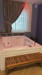 a large pink bath tub in a room with a window at La Piana Hotel in Tito