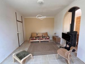 a living room with a couch and a tv at Maison des Artistes in Villeblevin