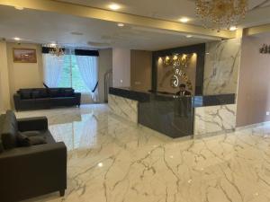 a lobby with a marble floor with a bar in it at Riviera Resort in Naran