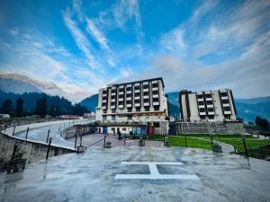a large building in the middle of a parking lot at Riviera Resort in Naran