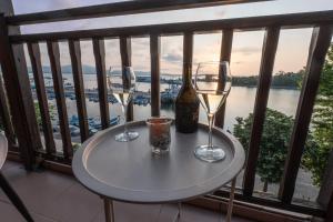 two glasses of wine and a bottle on a table on a balcony at Guest House Fotini 2 in Sozopol