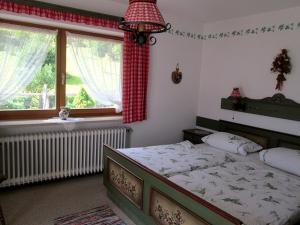 a bedroom with a large bed and a window at Haus Öfenbichl Ferienwohnungen in Ramsau