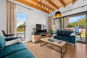a living room with a couch and a tv and a table at Villa Hera with Private Pool in Istria Quiet Location and Modern Design in Orbanići