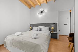 a white bedroom with a large bed and a clock on the wall at Villa Hera with Private Pool in Istria Quiet Location and Modern Design in Orbanići +36 photos