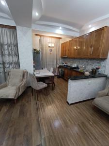 a living room with a table and a kitchen at A cozy corner in Saburtalo in Tbilisi City
