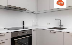 a kitchen with white cabinets and a sink and a stove at Luxury And So Comfortable Studio in Tallinn