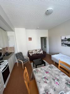 a kitchen and living room with a table and a couch at Yksiö Kiertokatu in Pori