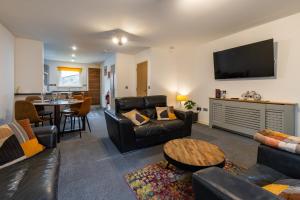 a living room with leather furniture and a flat screen tv at Dundee City centre apartment - 3 bedrooms sleeps 6 in Dundee