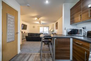 a kitchen and living room with a counter and a microwave at Dundee City centre apartment - 3 bedrooms sleeps 6 in Dundee