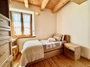 een kleine slaapkamer met een bed en een raam bij Alpine Escape 6 in Bormio