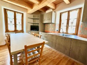 een keuken met een tafel en stoelen in een kamer bij Alpine Escape 6 in Bormio