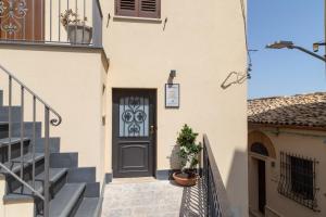 a building with a door and stairs with a plant at Zeus Atabyrios 3 - Open Space in Agrigento