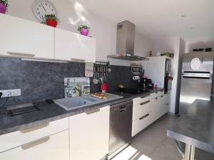 a kitchen with white cabinets and stainless steel appliances at Luxueux P3 au Grau-du-Roi avec Terrasse et Parking Privé - FR-1-307-73 in Le Grau-du-Roi