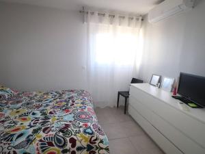 a bedroom with a bed and a dresser with a television at Luxueux P3 au Grau-du-Roi avec Terrasse et Parking Privé - FR-1-307-73 in Le Grau-du-Roi +16 photos