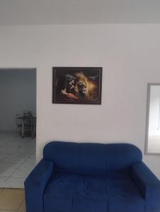 Sofá azul en una habitación con una foto en la pared en Hostel cabo frio, en Cabo Frío