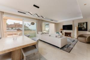 a living room with a table and a couch at Luxury Beachfront Penthouse Marbella - heated pool & seaviews in Estepona