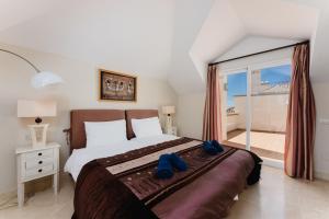 a bedroom with a bed with blue shoes on it at Luxury Beachfront Penthouse Marbella - heated pool & seaviews in Estepona +13 photos