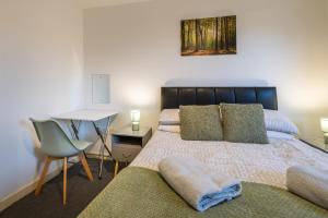 a bedroom with a bed with a desk and a chair at Dundee City centre apartment - 3 bedrooms sleeps 6 in Dundee