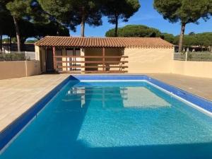 a blue swimming pool in front of a house at Charmante villa climatisée avec piscine, parking privé et proche plage, idéale pour vacances au calme - FR-1-607-158 in Cap d'Agde