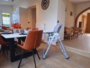 a dining room with a table and chairs and a clock at Chez Camil in La-Roche-en-Ardenne