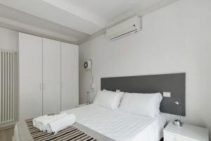 a white bedroom with a large bed with white pillows at Green House in Sestri Levante